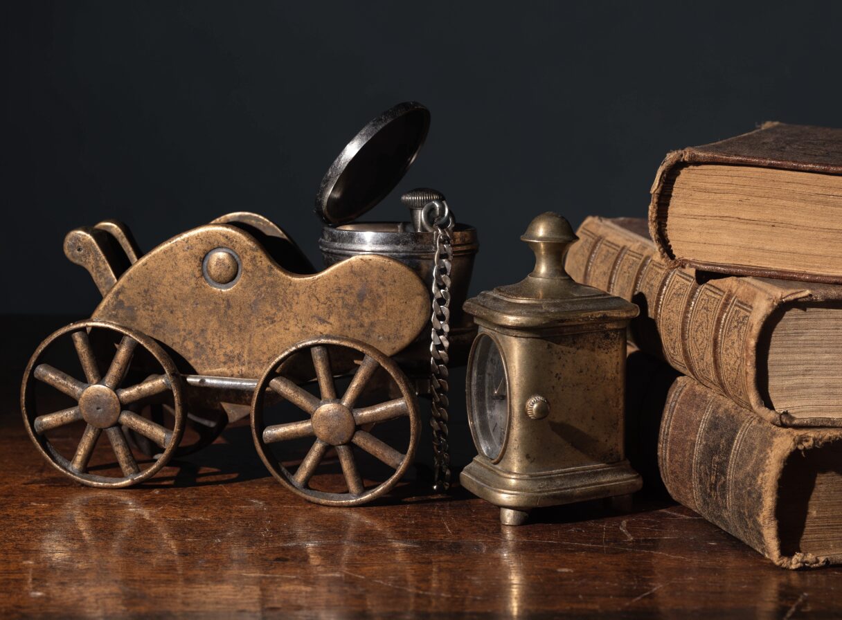Vintage collectibles including a tin toy, pocket watch and carriage clock, representative of the memorabilia we handle